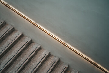 Illuminated handrail running diagonally aside a marble staircase in Luxury Hotel