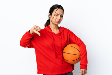 Young woman playing basketball over isolated white background showing thumb down with two hands