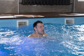 A handsome man is swimming in the pool. Healthy lifestyle