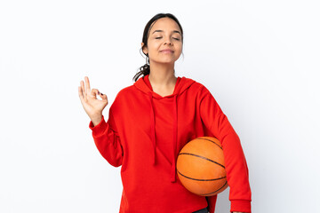 Young woman playing basketball over isolated white background in zen pose