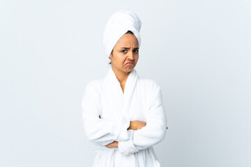 Young woman in bathrobe over isolated white background making doubts gesture while lifting the shoulders