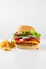 cheese burger, with meat, chicken, bacon, tomatoes, onion, lettuce, potatoes, french fries, ketchup. white background
