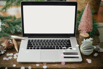 Christmas Sales and shopping online. Laptop with blank screen and credit card on rustic wooden table with stylish christmas ornaments and pine tree. Black friday and cyber monday. Space for text