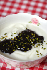Naturjoghurt mit schwarzer Johannisbeerkonfitüre und Pistazien 