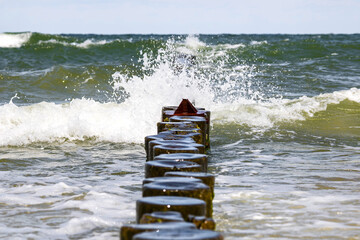Landscapes of Poland. Breakwater  at Baltic sea. Wavy water.