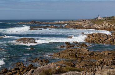 Fototapeta na wymiar Vista de la costa de Oia con el océano Atlántico y un molino de viento.
