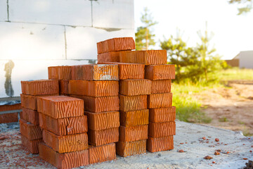 A stack of orange bricks at a construction site. Construction materials, delivery, warehouse. Copy space