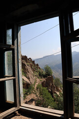 amazing view from the window of abandoned house in Gamsutl, Dagestan to the picturesque valley and mountains