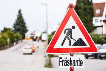 Baustellenschild an einer befahrenen Straße