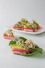 sushi pizza with blue background, leaf plate with neptune salad