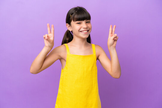 Little caucasian kid isolated on purple background showing victory sign with both hands