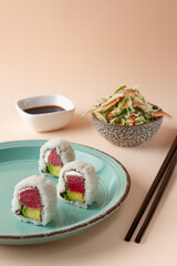 sushi, neptune salad, wakame salad on cream, brown background. 