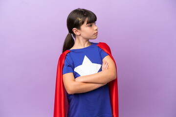 Little kid isolated on purple background in superhero costume with arms crossed © luismolinero