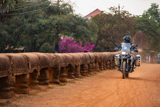 Man riding his adventure motorbike over Dragon Bridge in Cambodia