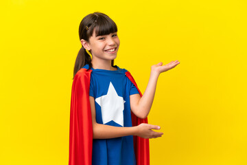 Little super hero kid isolated on purple background extending hands to the side for inviting to come