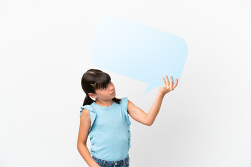 Little caucasian kid isolated on white background holding an empty speech bubble and with sad expression