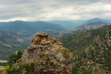 large boulder and mountain range in the background.