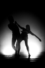 Fototapeta na wymiar modern ballet dancers performing. motion blur and smoke in the air