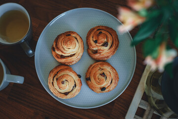 Fototapeta premium Homemade traditional breakfast: coffee with bun, snail with raisins.