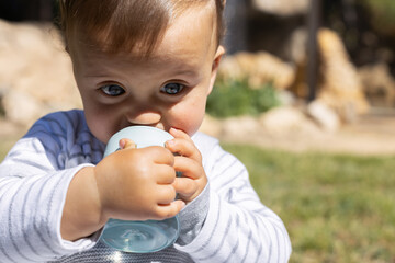 Boy drinking his bottle in a sunny day