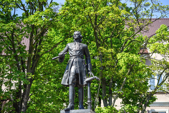 Monument to Peter the Great against a green tree.
