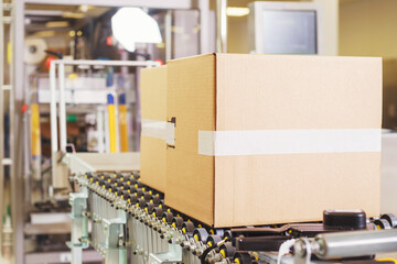 Sealed cardboard box on a conveyor belt in a factory