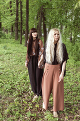 fashion twin girls posing against the background of a wooden lan