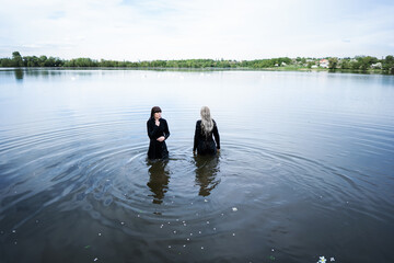 fashion girls twins on the lake posing against the backdrop of w
