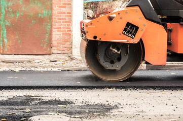 Laying of asphalt. Road roller tamping asphalt