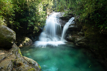 Obraz premium Beautiful green rainforest waterfall with crystal clear water pool