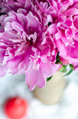 peonies in a vase and a red candle, free space
