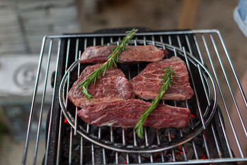 beef steaks marinated in spices and herbs are grilled with rosemary