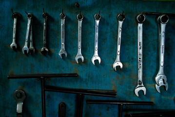 set of key wrench hanging on dirty blue multiplex. 