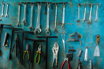 set of key wrench hanging on dirty blue multiplex. 
