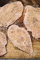 Tenderized raw chicken breasts with Italian seasoning