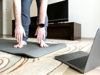 Man does stretching at home online, tilting downwards