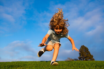 Boy falling down on grass. Kid falling off at the park. Child insurance and childcare.