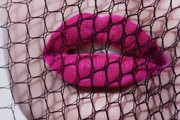 Close-up beauty shot of lips of a young pretty model with bright cat-eye make-up. Pink lips. Gorgeous beauty portait