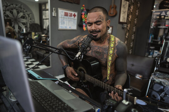 tattoo guy all in tattoos plays the guitar and sings in the tatt