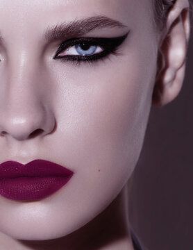 Close-up beauty shot of young pretty model with bright cat-eye make-up. Black Eyeliner. Pink lips. Bol and daring beauty portait