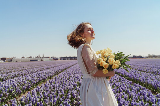 Full length portrait of woman standing on hyacinth fields