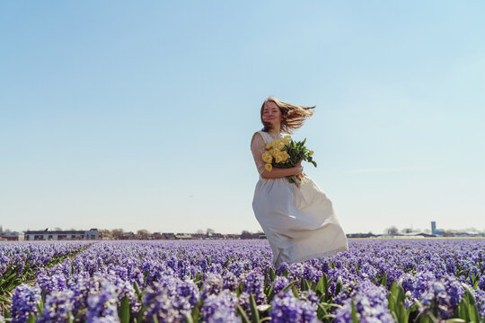 Full length portrait of woman standing on hyacinth fields
