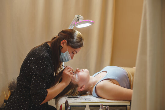 Aesthetic medicine: eyelash extension procedure for young woman