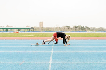 athlete with prosthetic leg preparing on the starting blocks
