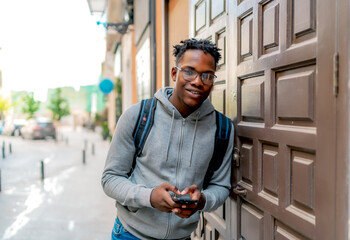 young african man using his smartphone in the city