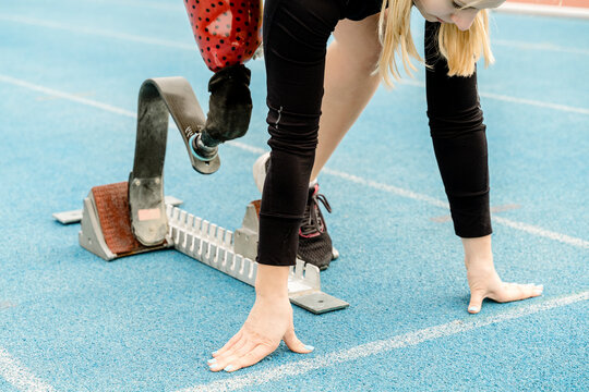 Crop sportswoman with disability standing in crouch start position - Powered by Adobe