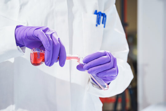 Researcher holds a flask with chemicals and reagents in his hands