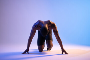 Black male runner standing in crouch start position