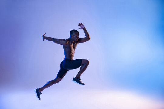 Black sportsman jumping in studio