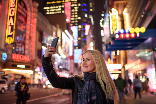 Smiling woman taking selfie in famous city center